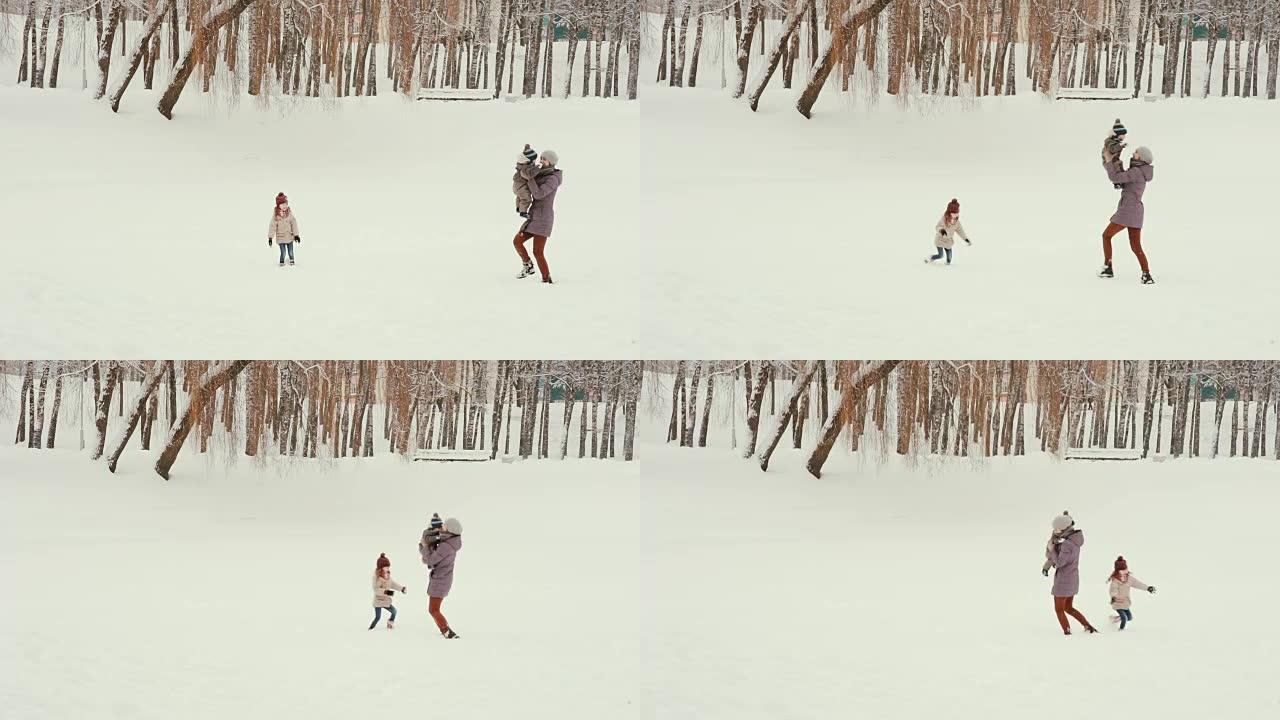 年轻的母亲和她的孩子在雪地里玩耍和玩耍