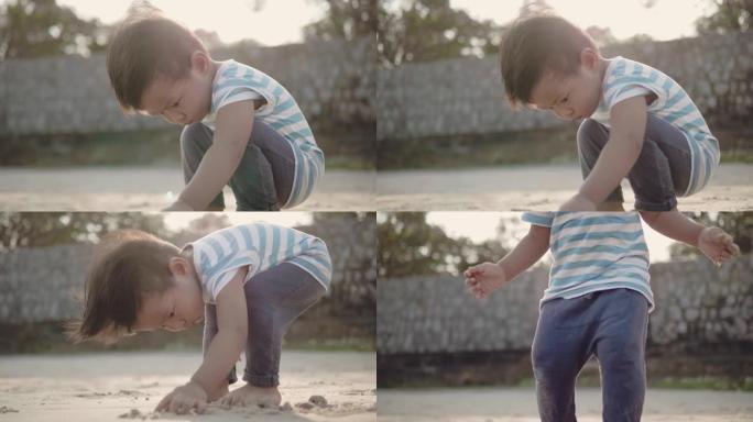 一个小男孩 (12-23个月) 在沙滩上玩耍