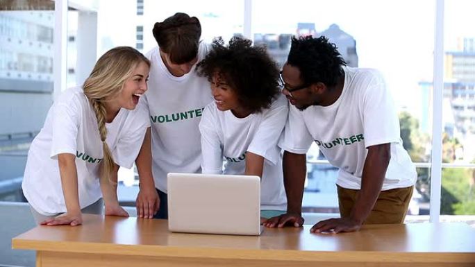 一群志愿者一起使用笔记本电脑