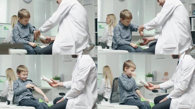 男医生从一个男孩痊愈的手上取出石膏。男孩很开心。