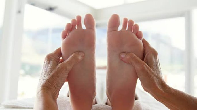 女性治疗师按摩病人的脚的特写
