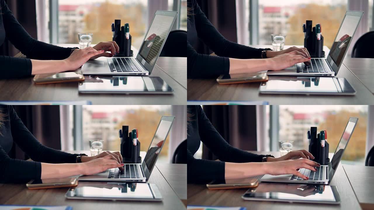 女性手在笔记本电脑上慢慢打字。