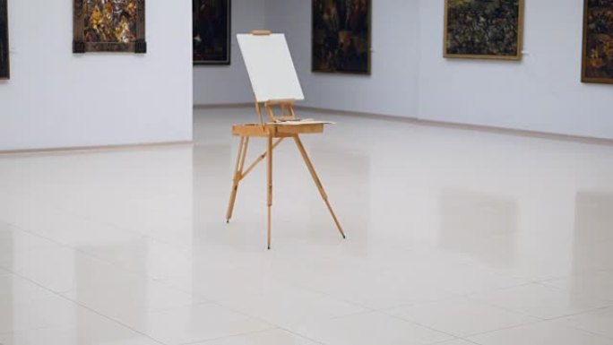 画架上有白色画布的steadicam拍摄。它站在画廊的中央。4K。