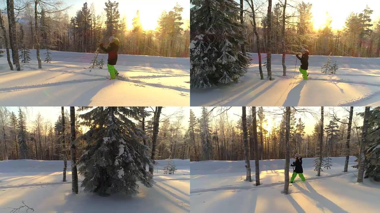 金色冬季日出时，穿着冬装的空中女孩雪鞋在深雪上行走