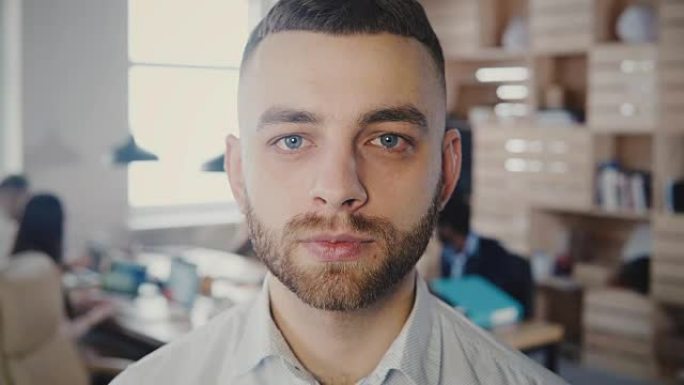 近距离肖像的年轻欧洲成功企业家看在办公室的相机，改变面部表情4K