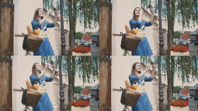 黑发女孩抚摸她的头发，自拍，站在自行车上，篮子里放着鲜花和面包，慢动作