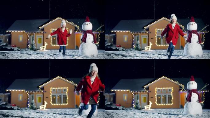可爱的小女孩跑出房子，穿过前院。孩子在冬天的夜晚在房子装饰的花环的背景下玩得开心。站在院子里的圣诞树