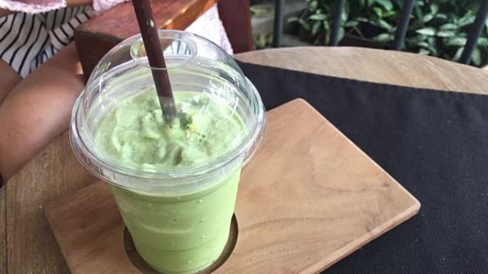 木质桌子上的玻璃杯中管有美味的绿茶冰壶。