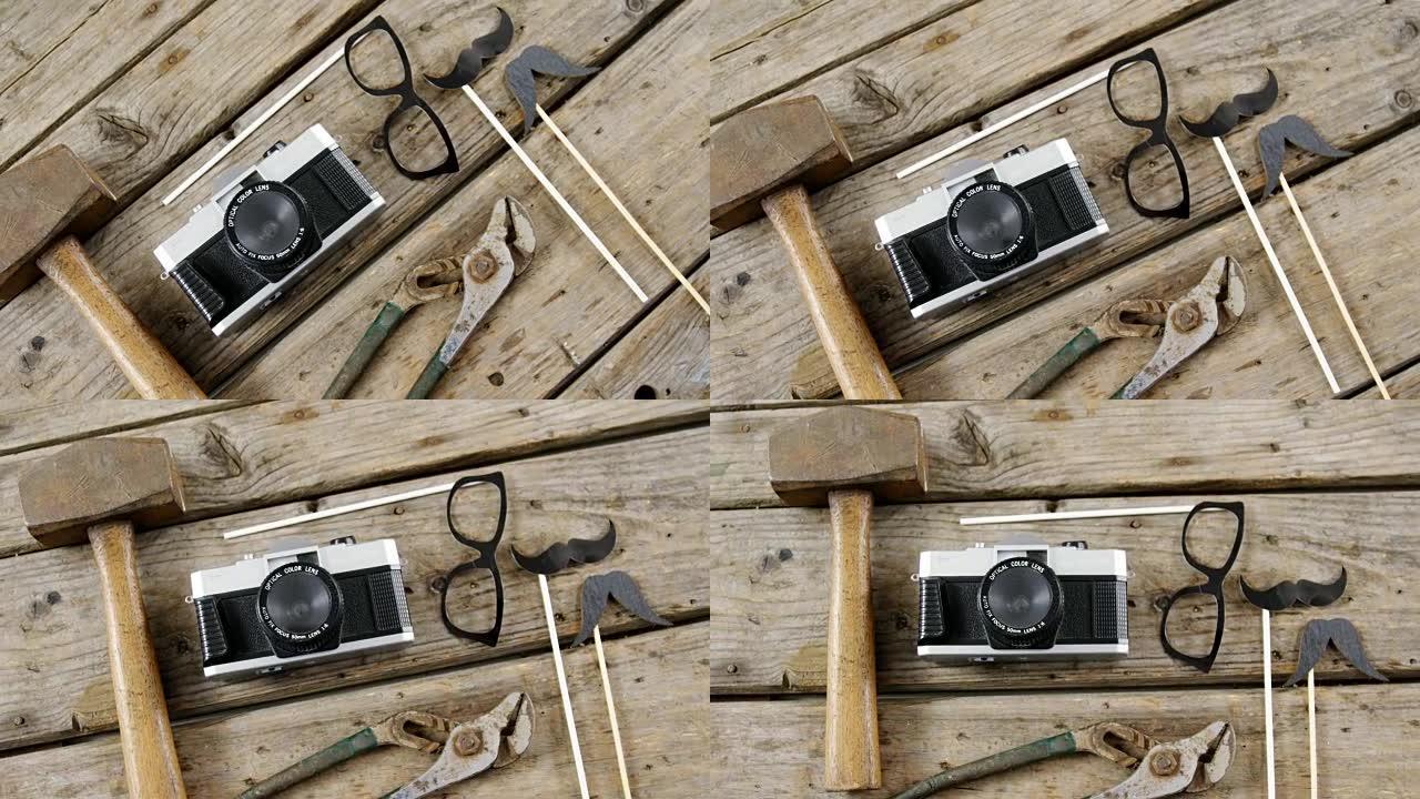 工作工具、老式相机、眼镜和木板上的假胡子