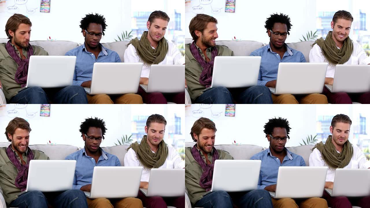三个同事使用笔记本电脑