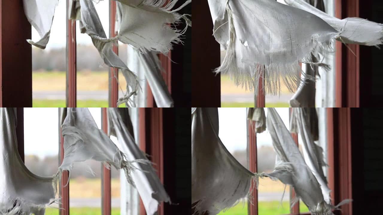 慢动作: 旧屋窗户上的缝隙窗帘在风中拍打