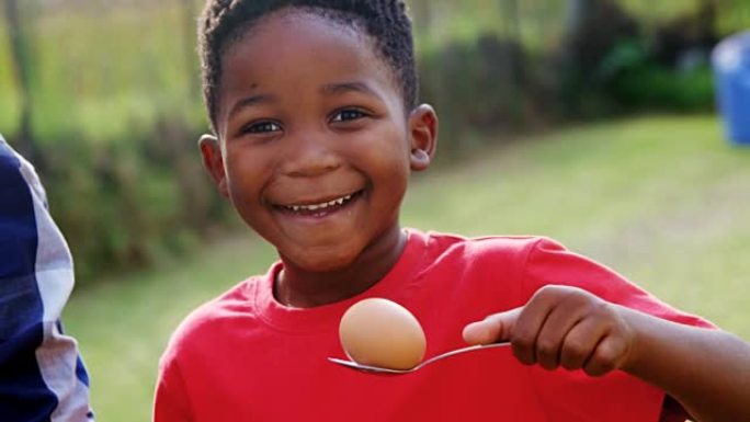 快乐男孩在后院拿着鸡蛋和勺子4k