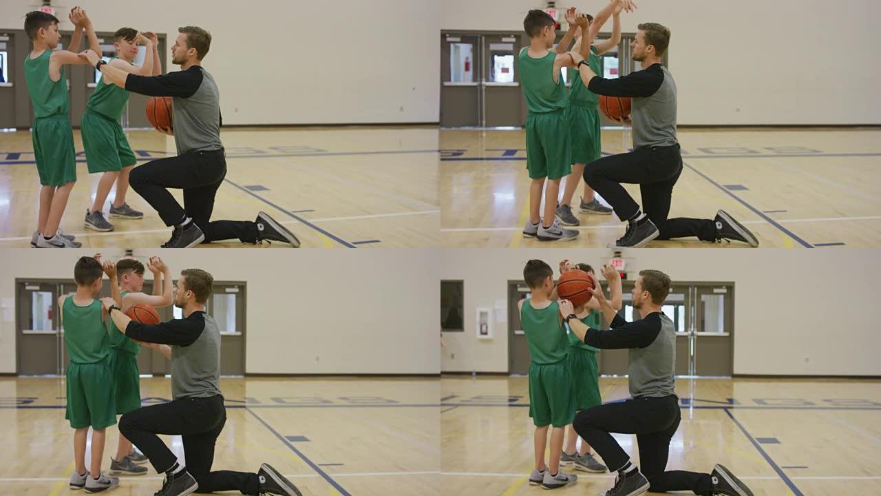 篮球教练向男孩展示适当的投篮技术