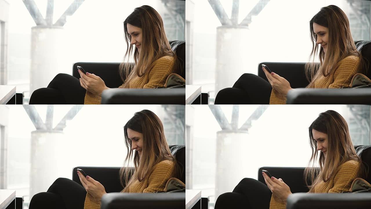 年轻的黑发女人坐在靠近窗户的咖啡馆里，使用智能手机。迷人的女性在互联网上聊天