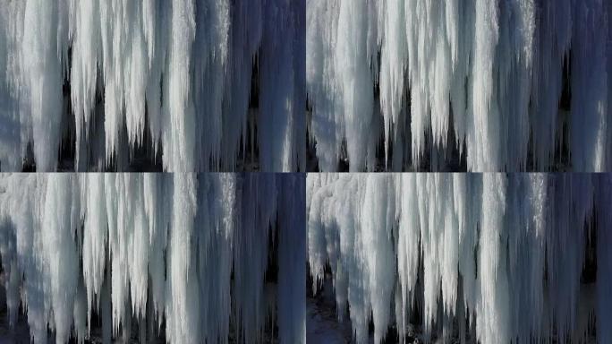 空中特写: 在阳光明媚的冬天，在瀑布周围飞舞成冰柱