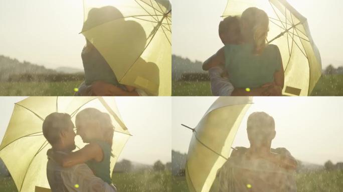 慢动作: 一对夫妇在雨中跳舞时躲在黄色的伞吻后面。