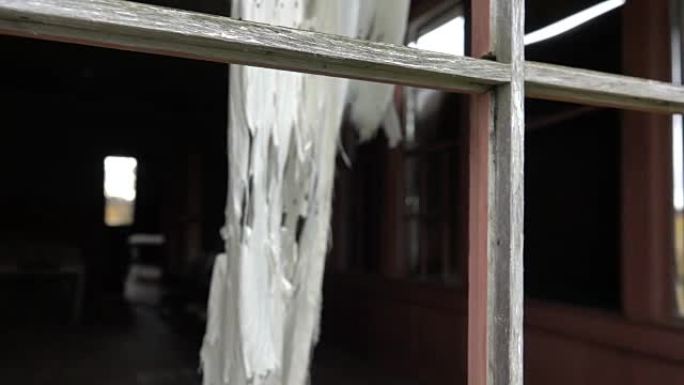 慢动作: 破旧小屋窗户上的窗帘在风中摇曳