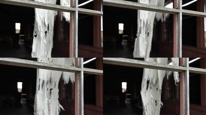 慢动作: 破旧小屋窗户上的窗帘在风中摇曳