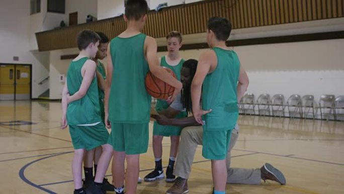 小学男孩挤在篮球教练周围
