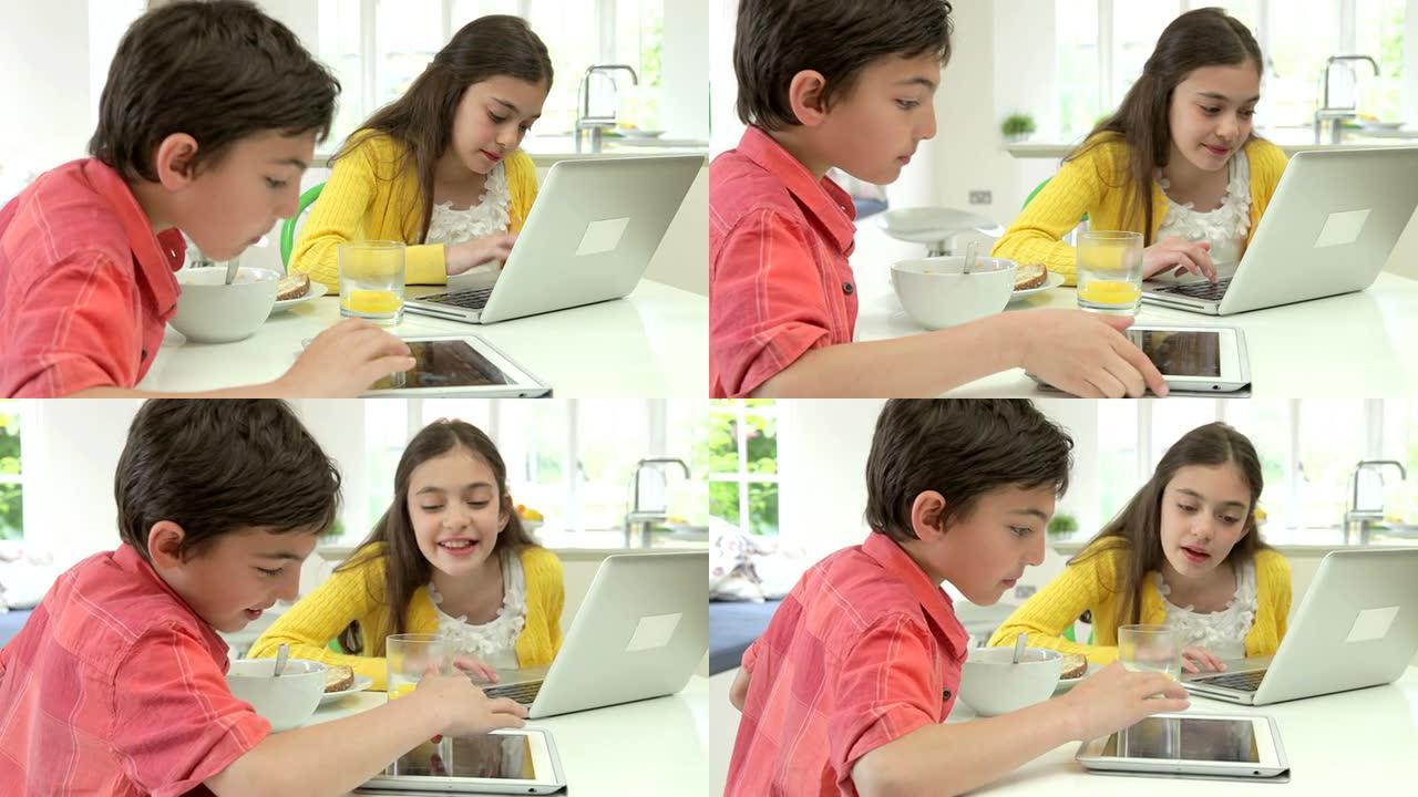早餐时使用数字平板电脑和笔记本电脑的儿童