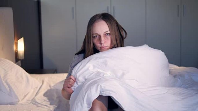 生病的女人把自己裹在毯子里。特写。