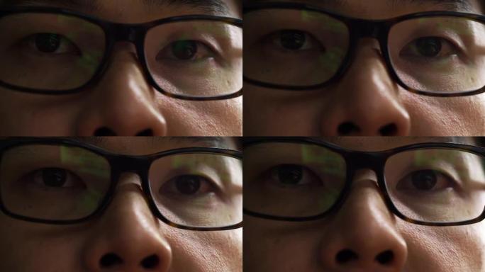 4k镜头的亚洲男子眼睛戴着眼镜在他的电脑屏幕上工作