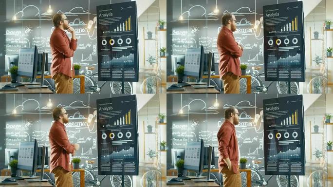 Marketer查看交互式触摸屏白板，显示有关统计增长的最新图形和图表。他在创意办公室工作。