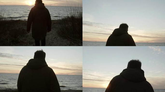 年轻人晚上在沙滩上散步。悲伤的男性在日落时独自在海滩上度过时光