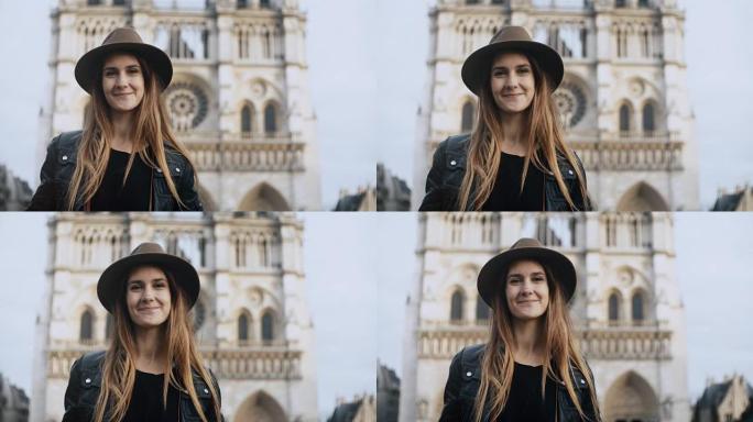 戴着帽子的年轻美女的肖像站在法国巴黎圣母院附近，看着相机