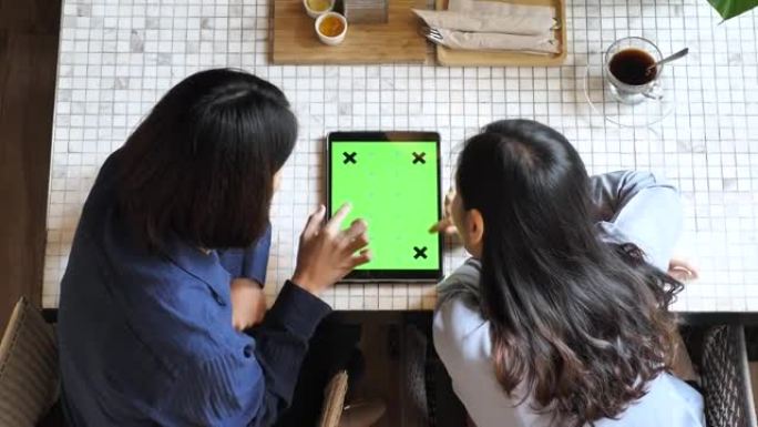 两人使用平板电脑绿屏，高角度视图