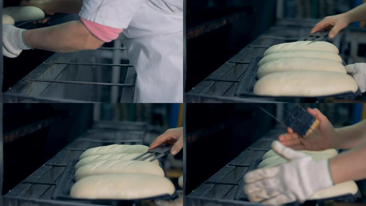 面包师正在长面包上刮擦。