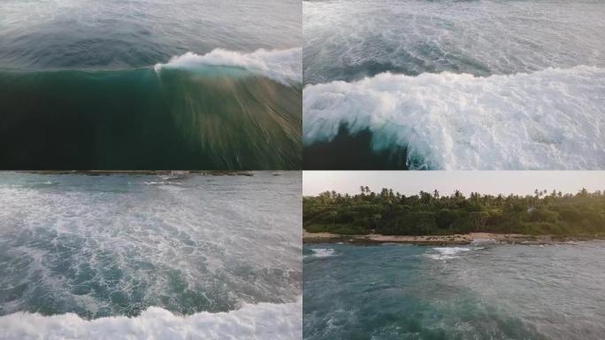 航空摄影机跟随巨大的海浪浪潮冲向岸边，揭示了充满热带树木的美丽阳光明媚的异国岛屿