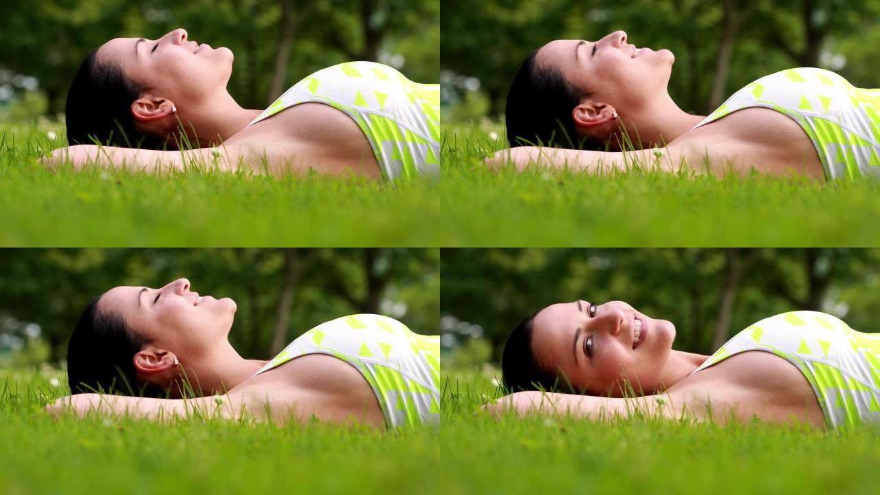 漂亮的黑发女人躺在草地上