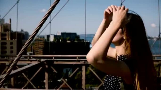 相机跟随美丽快乐的欧洲女孩穿着复古太阳镜，金色头发沿着布鲁克林大桥4K