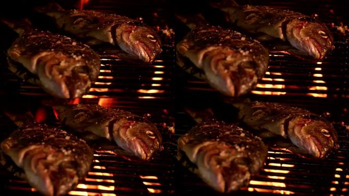 两只整条鱼在发光的夜间烧烤中烧烤