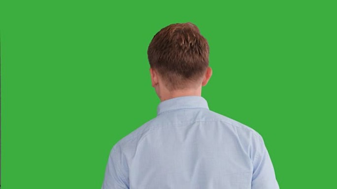 年轻的白人站在绿屏背景下。男性隔离在色度键上。休闲商务专业肖像