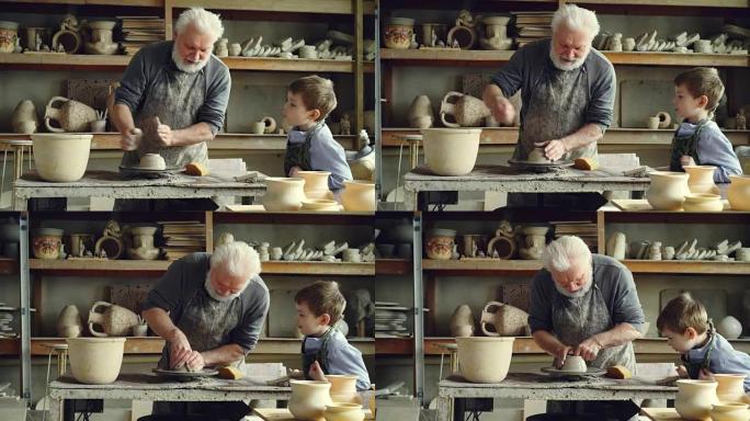 有爱心的高级祖父正在向年轻的孙子展示如何在小作坊里用粘土在投掷轮上工作。陶器、家庭爱好和手工艺概念。