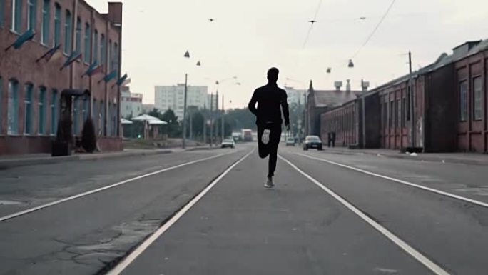 2在1。一个男人在老城的街道上跑得很快。真正的时间。自由的概念。镜头紧跟在年轻运动员身后
