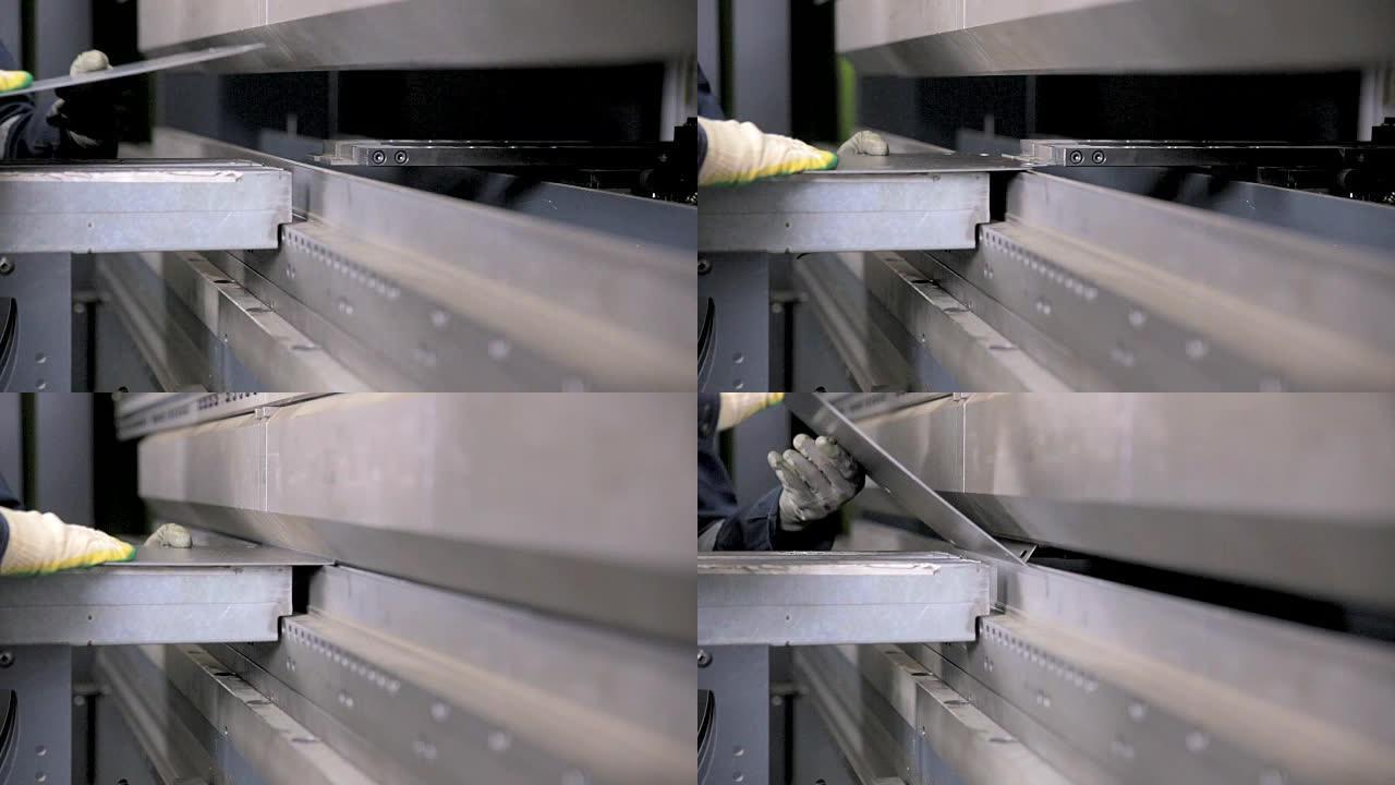 工人的手在工厂的现代弯曲工业机器上弯曲金属板
