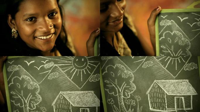 快乐的少女在黑板上展示粉笔画
