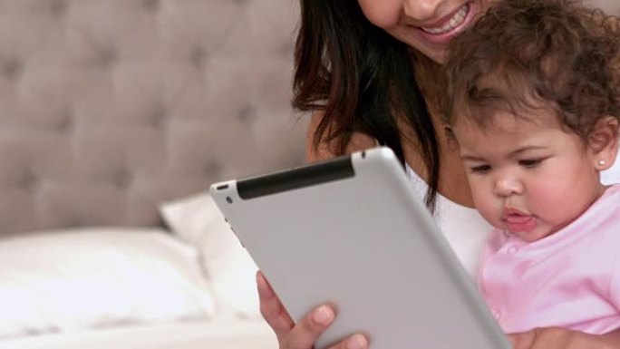 母亲和她可爱的宝宝一起使用数字平板电脑