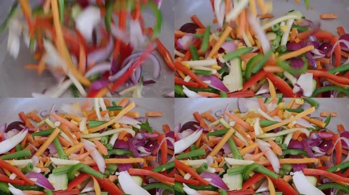 将五颜六色的稀薄蔬菜倒入锅中的慢动作镜头