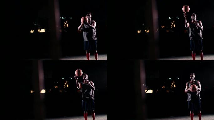 篮球运动员在夜间在球场上用手指旋转球