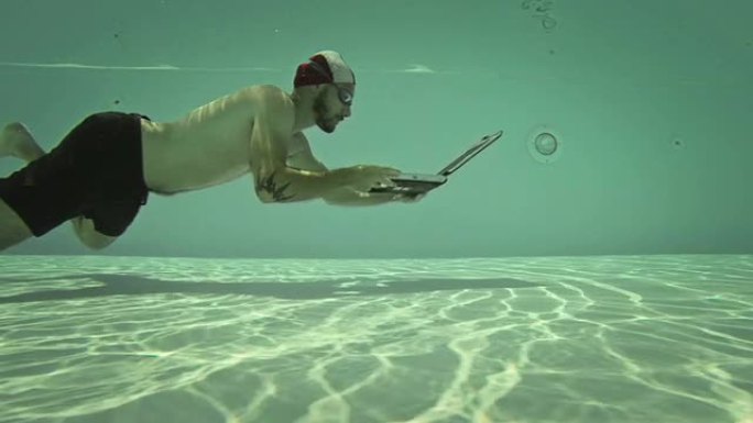 一名男子在水下使用笔记本电脑