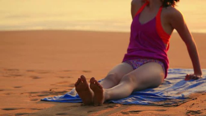 年轻女孩坐在热带海滩上