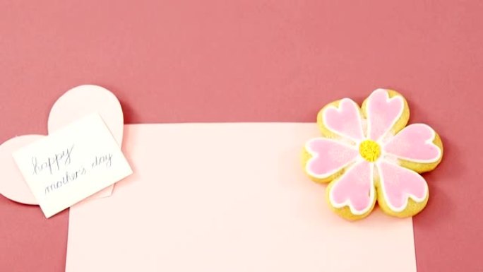 花形饼干，红色信封上的心形卡片，粉红色背景