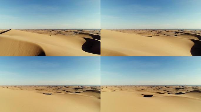 日落时飞越沙漠沙丘的鸟瞰图
