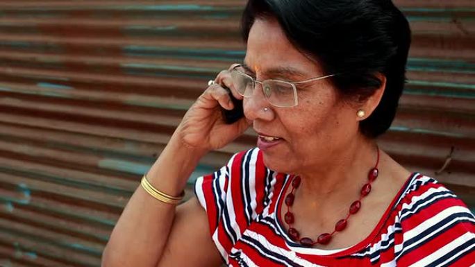 一名资深亚裔印度妇女在打手机