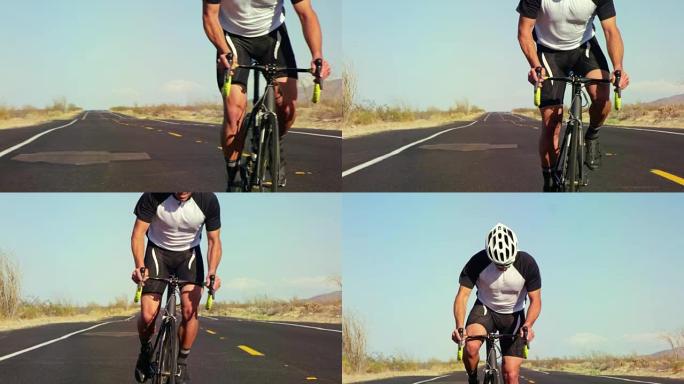 在阳光明媚的日子里，在沙漠路上外面的公路自行车上骑自行车的人的慢动作特写