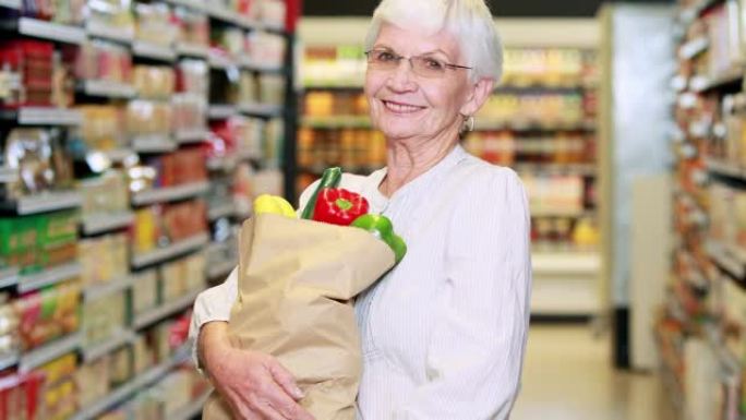 杂货店里有蔬菜袋的高级妇女
